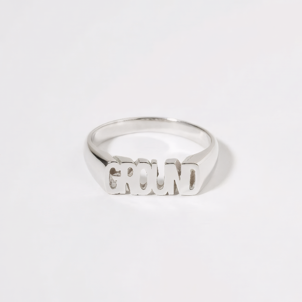 Silver ring with 'GROUND' engraved on a white background