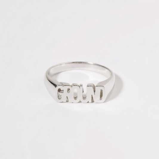 Silver ring with 'GROUND' engraved on a white background